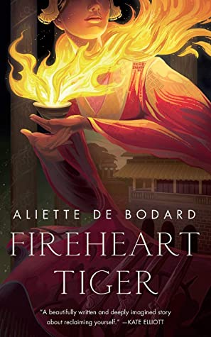 Cover of Fireheart Tiger, featuring the title and author's name over an illustration of a woman (face cropped above the nose) wearing flowing red and white robes, with flames bursting from a vessel she's holding. In the slit of her sleeve, a Vietnamese palace is visible