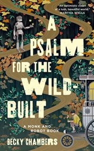 Cover for "A Psalm for the Wild-Built: A Monk and Robot Book," with title and author Becky Chambers' name over an earth-tone background of greenery and brown and yellow leaves, with dirt paths wending throughout from the top to bottom. At the top left corner there's a robot, and in the bottom right there's a person sitting on an old-fashioned cart.