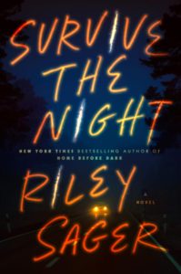 Cover of "Survive the Night," with the title and author Riley Sager's name in huge, orangeish handwritten font, against a dark night backdrop with a road and car headlights a the bottom