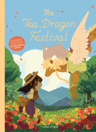 the cover of "The Tea Dragon Festival," with yellow cursive font over the top of an illustration from the graphic novel: A darker-skinned femme person, wearing a large straw sun hat, purple short pants, and cream top, carrying a messenger bag, greets a large orange dragon, with white wings and a green outfit. They are standing in a field of red, orange, and yellow flowers, with trees and mountains in the background against a blue sky. 