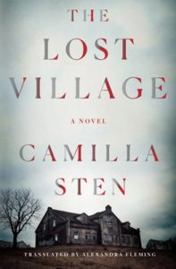 Cover of "The Lost Village," with title in red font over the sky of a photo of a derelict, wooden spooky building next to a leafless tree