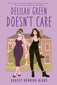 Cover of "Delilah Green Doesn't Care," featuring illustrations of 2 white women, one femme, one slightly punker with tight black leggins and a tank, holding hands in front of a large house. The background is lavender purple. 